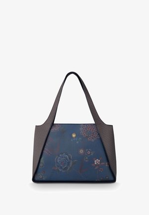 Blaue Ledertasche mit Blumenmuster und langen braunen Griffen, die ein kleines goldenes Emblem in der Mitte vorne zeigt.