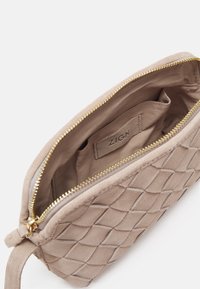 Borsa a pochette in suede beige con un motivo intrecciato, zip dorata e fodera in tessuto. L'etichetta interna recita "ZIGN."