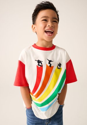 Weißes T-Shirt mit roten kurzen Ärmeln, das ein farbenfrohes Wellenmuster in Orange, Gelb, Grün und Blau sowie schwarze Skateboarder-Grafiken zeigt.