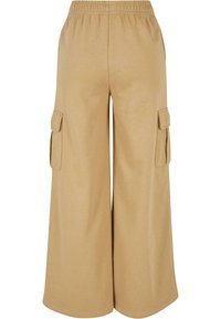 Beżowe spodnie cargo o szerokich nogawkach wykonane z miękkiego materiału, z elastycznym paskiem w talii i dwiema bocznymi kieszeniami cargo.