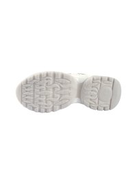 Semelle de sneaker blanche avec un motif de grip texturé, présentant des rainures et des formes arrondies pour une meilleure adhérence, réalisée en caoutchouc avec une finition lisse.