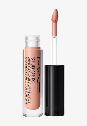 Correcteur de couleur MAC Studio Fix 24 heures avec un applicateur teint nude et un bouchon noir à vis à côté du tube transparent.