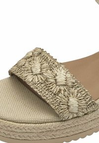 Sandalo espadrillas beige con toma in rami intrecciati che presenta motivi floreali, base in tessuto testurizzato e suola in gomma neutra.