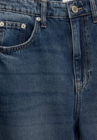 Jeans din denim de un albastru închis, cu o textură netedă, având un buzunar frontal, un nasture din metal și detalii de cusătură galbenă în contrast.