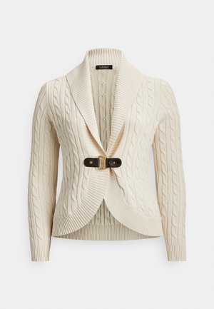 Krēmkrāsas adīts džemperis ar jaku apkakli un tumši brūnu ādas sprādzi priekšpusē, garām piedurknēm un ribaina apmala.