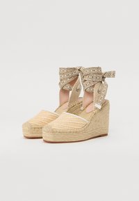Espadrilky na klínu s vzorovaným plátnem v světle béžové barvě, jutové podrážky a dekorativní vázání kolem kotníků v kontrastní béžové tkanině.