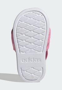 Růžová podrážka tenisky s texturovanou bílou gumou, opatřená hranatým vzorem pro lepší přilnavost a vyraženým logem „adidas“ poblíž paty.
