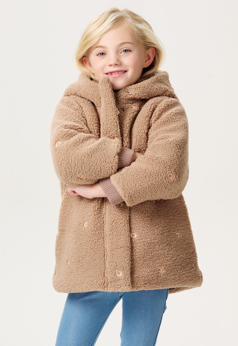 Beige Fleece-Mantel mit Kapuze, oversized Form und gerippten Bündchen. Verfügt über dekorative orangefarbene Punktakzente und eine weiche Textur.