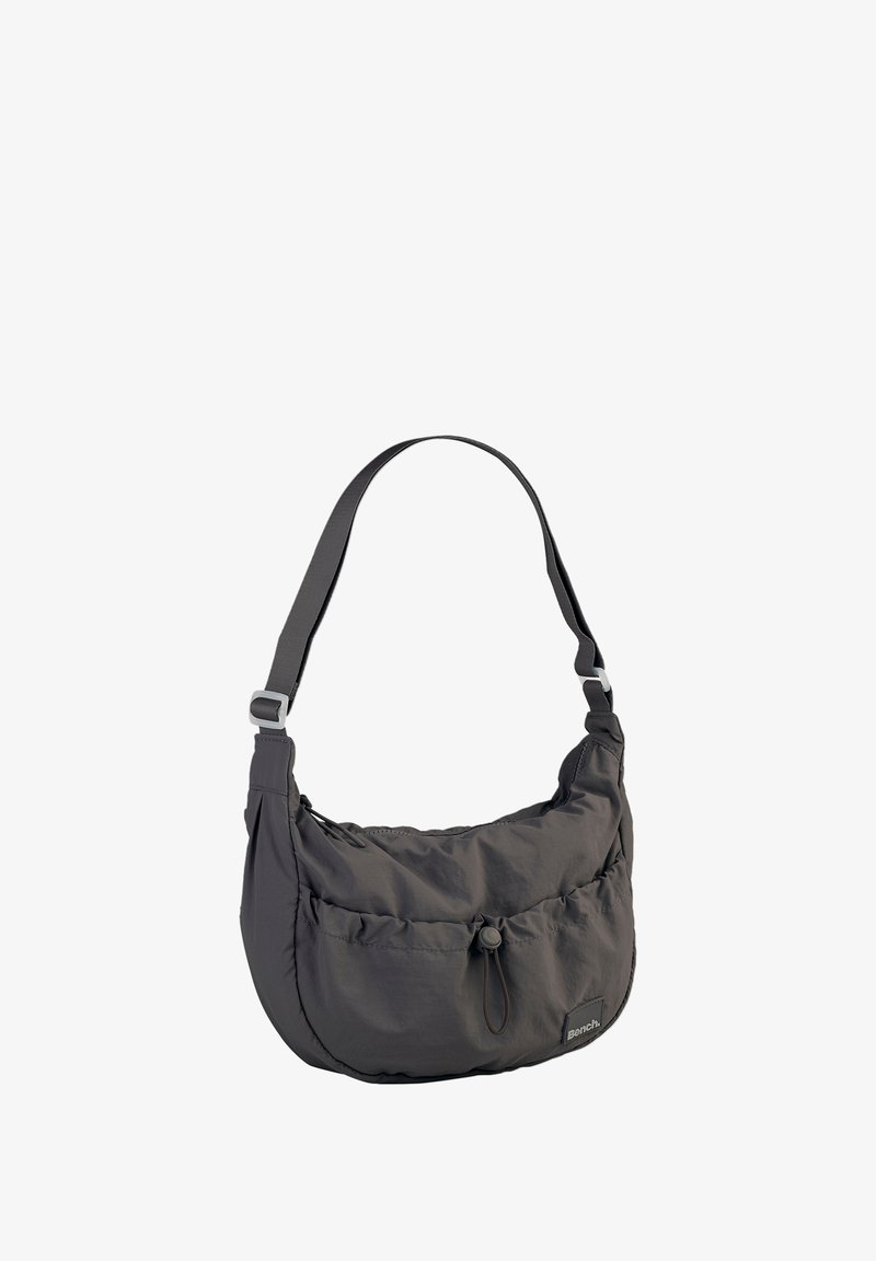 Grey nylon shoulder bag with a soft, rounded shape, featuring a drawstring closure and adjustable strap, accented by a logo patch.