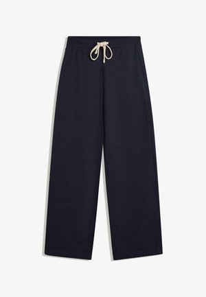 Námorníckomodré bavlnené tepláky s voľným strihom, elastickým pásom a krémovou šnúrkou na stiahnutie. Obsahujú bočné vrecká a prešívaný lem.