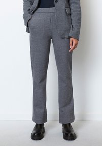 Grijze gestreepte broek van gestructureerde stof, met een getailleerde pasvorm, zijzakken en gecombineerd met zwarte chunky laarzen.