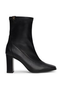 Botas de tobillo de cuero negro con punta afilada, tacón alto en bloque y un detalle de cremallera en el tobillo para facilitar su uso. Textura suave y un diseño elegante.