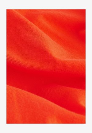 Lys orange stof med en glat, let tekstureret overflade. Materialet ser let ud og er foldet for at vise dybde og fald.