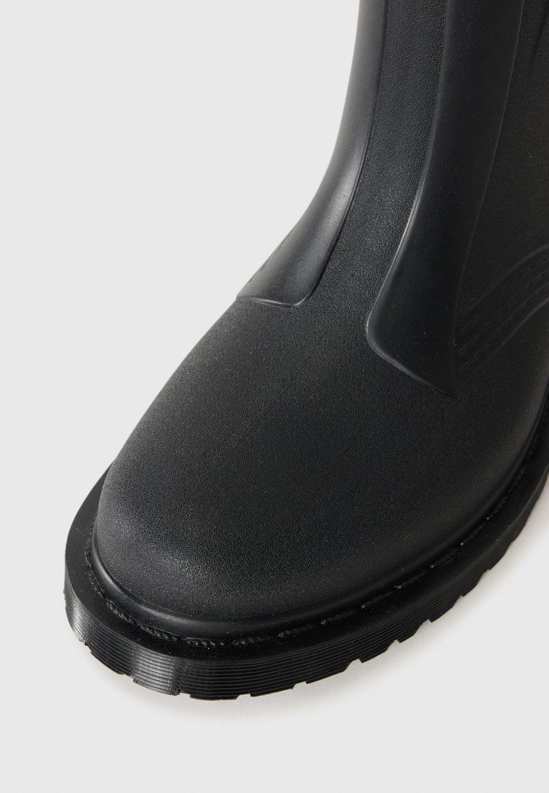 Schwarzer Gummistiefel mit einer strukturierten Oberfläche, abgerundeter Zehenpartie und einer dicken, geriffelten Sohle. Verfügt über ein glattes Panel am Schaft für zusätzlichen Halt.