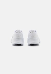 Weiße Sportschuhe mit einem strukturierten Mesh-Obermaterial, einem geschwungenen Fersendesign und einer Gummisohle. Mit "VAPORlite"-Branding an den Fersen.