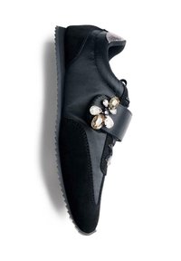 Sneaker nera con dettagli in camoscio e cinturino adornato con grandi decorazioni in gemme trasparenti e ambra.