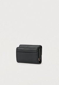 Μαύρο δερμάτινο πορτοφόλι με υφή, διαθέτει θήκες για κάρτες και κομψό διπλωμένο σχέδιο σε ουδέτερο φωτεινό φόντο.