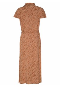 Ruskivärinen mekko, jossa on lyhyet hihat, valkoinen kukkakuosi, kaulus ja vyötärölle sidottu vyö. Pitkä, sivuhalkioilla varustettu helma liikkuvuuden helpottamiseksi.