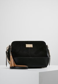 Czarna torebka na ramię z skóry i zamszu z akcentem w postaci złotych elementów, ozdobą z chwostem oraz regulowanym paskiem. Prostokątny kształt, gładka faktura.