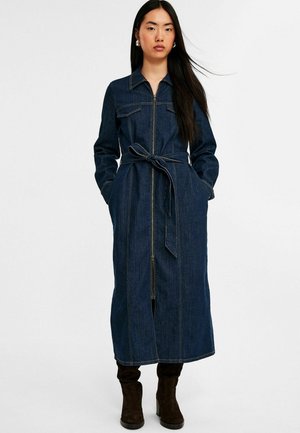Denimkleid mit Kragen, langen Ärmeln, einem Reißverschluss vorne und einem Bindegürtel. Verfügt über zwei Brusttaschen und kontrastierende Nähte.