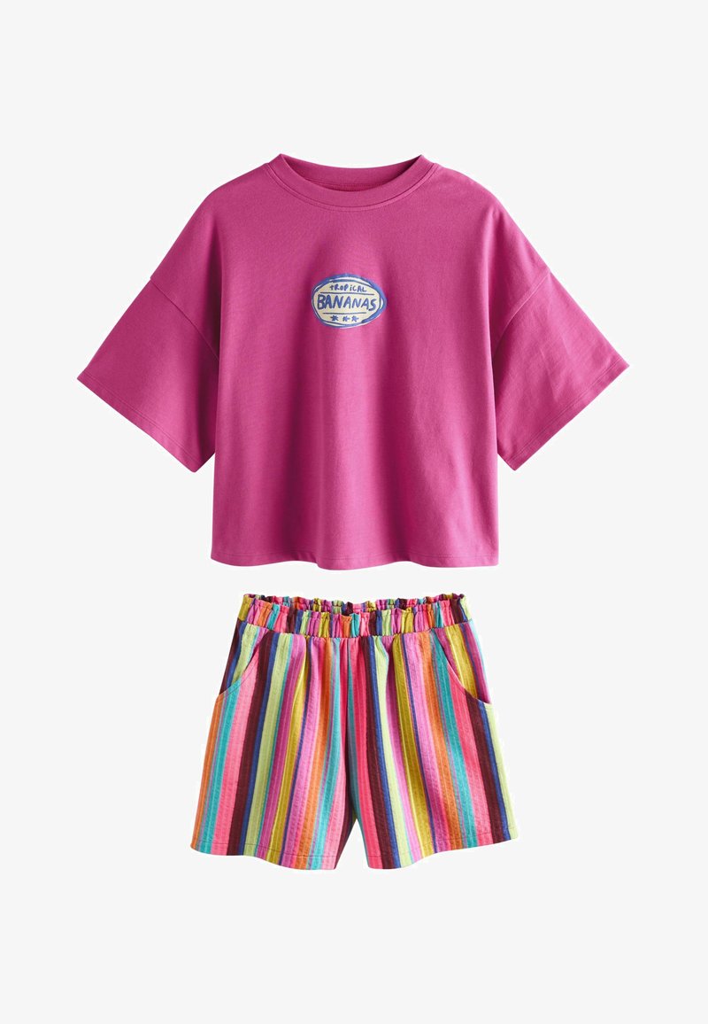 Top de manga corta oversize en color magenta con el logo "Tropical Bananas" y pantalones cortos con cintura elástica, rayas verticales multicolor y bolsillos laterales.