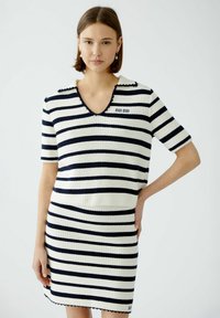 Gestreiftes Strickkleid in Weiß und Marineblau, mit V-Ausschnitt, kurzen Ärmeln, gewelltem Saum und "OUI OUI" Stickerei auf der Brust.