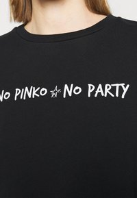 Svart sweatshirt med vit text som säger "NO PINKO NO PARTY." Tyget verkar glättat med en klassisk rund hals.