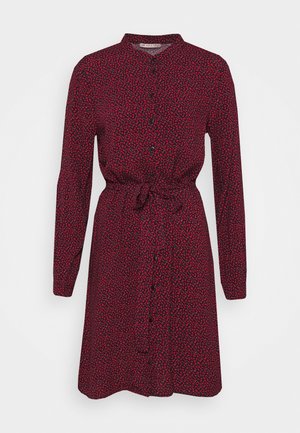 Vestito camicia rosso a maniche lunghe con piccolo motivo floreale, bottoni frontali, cintura in vita e colletto rotondo su sfondo semplice.