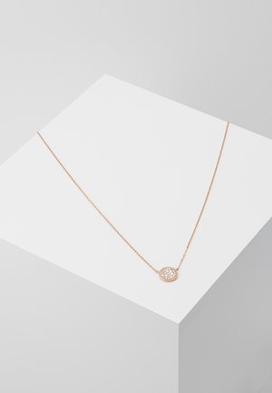 Collier délicat en chaîne d'or avec un pendentif rond orné d'un groupe de petites pierres précieuses claires et scintillantes, posé sur une surface blanche.