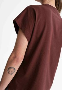 Braunes Kurzarm-T-Shirt mit lockerer Passform, aus weichem Stoff gefertigt, mit Rundhalsausschnitt und nahtlosem Schulterdesign.