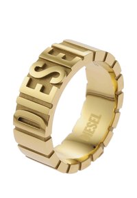 Bague en or au design épais, présentant le mot « DIESEL » en relief et une finition texturée. L'anneau a un motif segmenté.