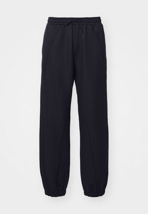 Čierne tepláky vyrobené z mäkkého materiálu, s elastickým pásom a šnúrkou, s manžetami na koncoch a dekoratívne prešívané švy.