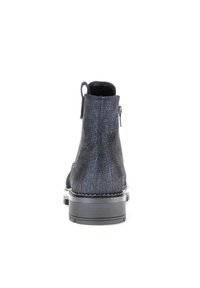 Zwarte enkellaarsjes met een gestructureerde afwerking, een rits aan de zijkant en een stevige rubberen zool. Het ontwerp heeft een ronde neus en een achtertab.