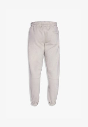 Pantalons de survêtement gris clair avec une taille élastique, des poignets côtes et une poche arrière unique. Fabriqués en tissu doux avec une texture lisse.