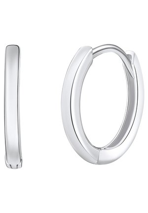 Boucles d'oreilles en argent poli, présentant un design élégant et courbé avec une texture lisse et un fermoir sécurisé.