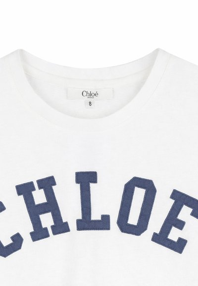 Biała koszulka z granatowymi literami wyszytymi na piersi, tworzącymi napis „CHLOÉ”, oraz metką z rozmiarem 8 wewnątrz kołnierza.