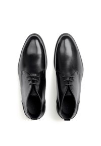 Schwarze Lederschuhe mit glatter Textur, rundem Zehenbereich und niedriger Schnittform, ausgestattet mit Schnürsenkeln und einem dezenten Logo auf der Innensohle.