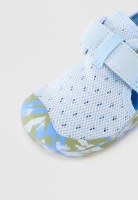 Μπλε πλεκτό παπούτσι με ενισχυμένη λαστιχένια μύτη σε πράσινο και μπλε με αφηρημένο μοτίβο και μία ρυθμιζόμενη λουρίδα για ασφαλή εφαρμογή.