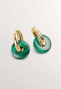Pendientes de aro dorados con colgantes circulares de malaquita que presentan un patrón verde a rayas y un agujero central. Texturas suaves y acabado pulido.
