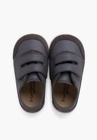 Scarpe in pelle grigia con strap in velcro, caratterizzate da una parte superiore in morbido suede, punta arrotondata e suola in gomma bianca. Nome del marchio stampato all'interno.