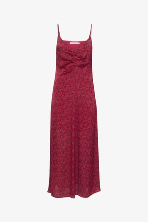 Rožinė gėlių suknelė be rankovių, su sukimo priekiu ir laisvai krintančia sijonine dalimi, siekiančia vidurinę kelio dalį.