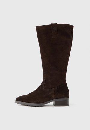 Brūnas zamšādas zābaki līdz ceļgalam ar noapaļotu purngalu, bloka papēdi un cilpu kājgalā, izceļoties ar smalkām šūšanas detaļām.