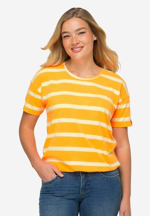 Camiseta de mangas cortas y cuello redondo en rayas naranja brillante y amarillo pálido. Material de algodón suave con corte relajado. Combinada con jeans azules.