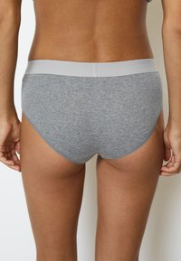 Mutande in cotone grigio scuro con una cintura liscia di un grigio chiaro. Presentano un design semplice e una texture morbida, con un taglio a copertura totale.