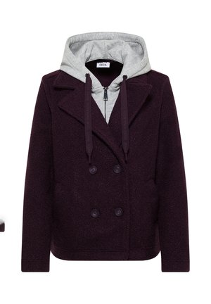 Manteau en laine double boutonnage de couleur violet foncé superposé sur un sweat à capuche gris clair avec des cordons de serrage noirs et une fermeture éclair à l'avant.