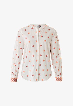Bílá látková košile s geometrickým oranžovým a fialovým vzorem, dlouhými rukávy a dekorativními vzorovanými manžetami. Zapínání na knoflíky vpředu.
