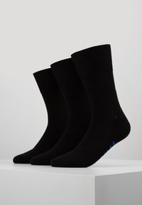 Calcetines de algodón negros con puño acanalado, textura suave y acento azul en la suela. Tres pares expuestos uno al lado del otro.