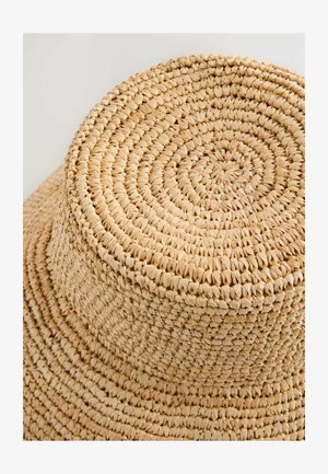 Geweven strohoed met een vlakke, ronde bovenkant en brede rand, voorzien van een natuurlijke beige kleur en een textuurrijke, intrigerende patroon.