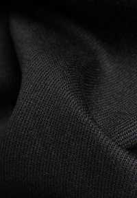 Svart tyg med en jämn, matt yta och en fin väv, som visar ett enhetligt utseende. Idealisk för olika tillämpningar.