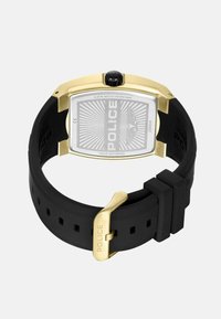Herenhorloge met een rechthoekige kast van roestvrij staal, zwarte siliconen band, gouden accenten en een geplateerde zilveren wijzerplaat. 5 ATM waterdicht.
